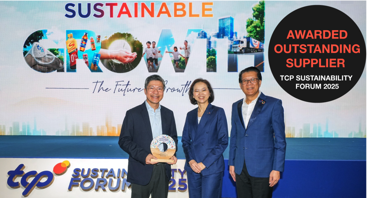 Three people in business attire receiving an award for "Outstanding Supplier"