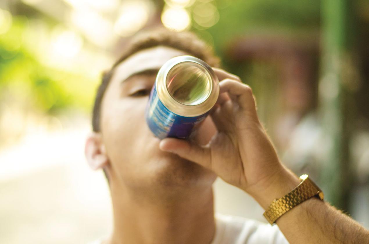 Young man enjoying a beverage outdoors