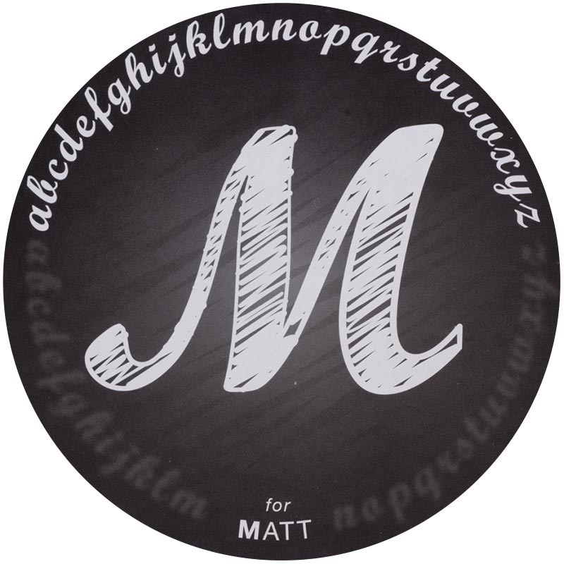 Matte-2x.jpeg A matte finish with a capital "M" sketched with white ink into a black background. The alphabet in lowercase is drawn in an arch above the "M."
