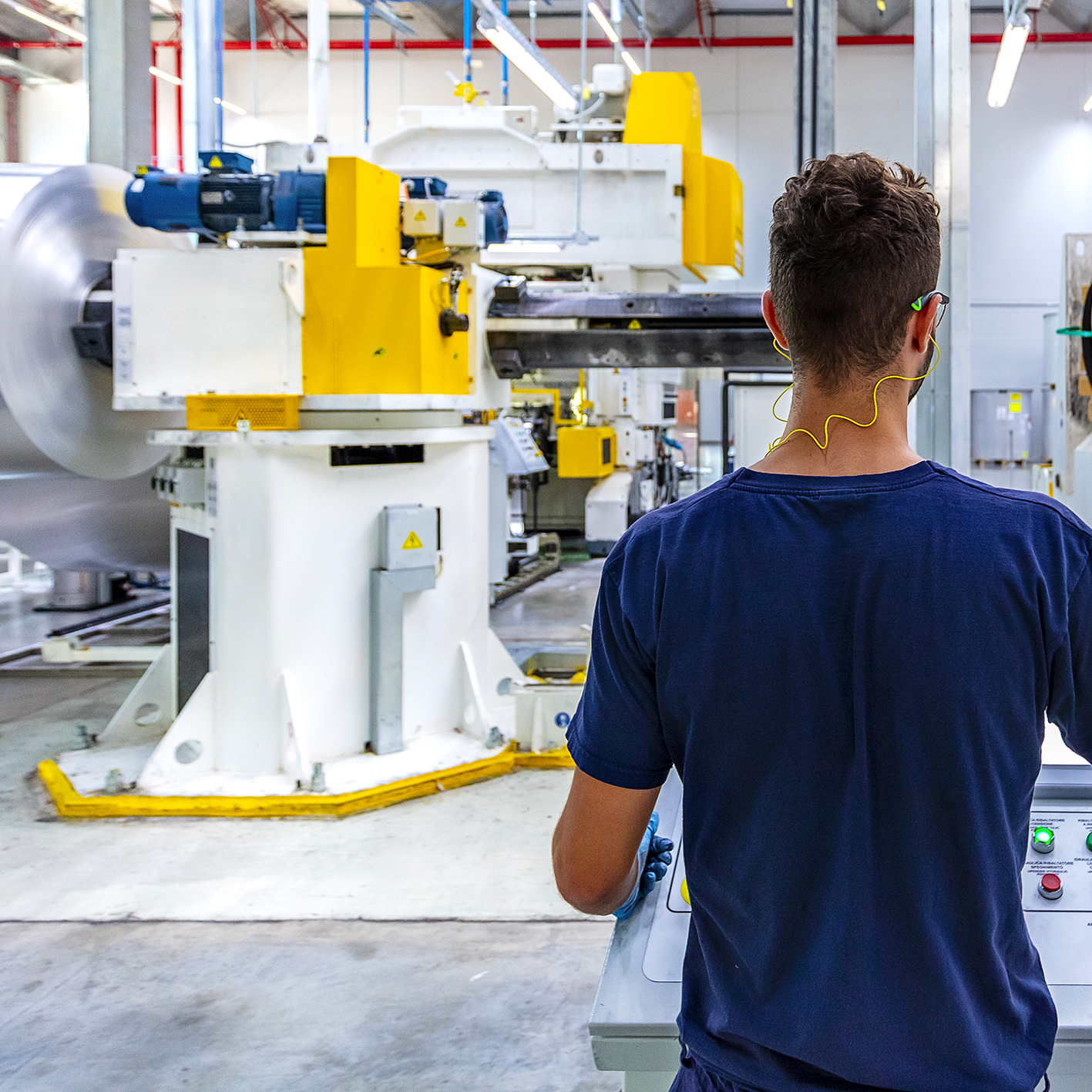 man looking at large white and yellow machines