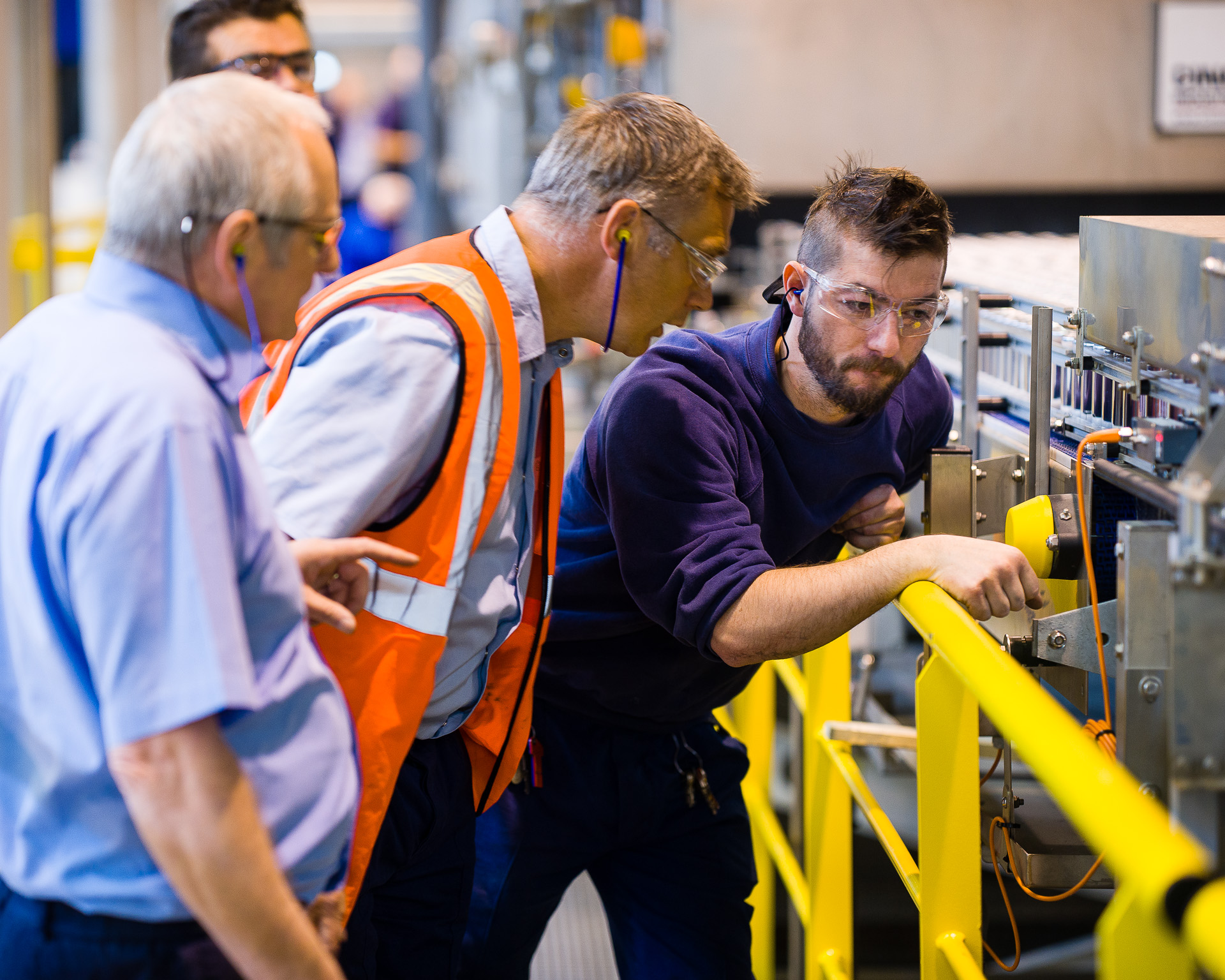 three white men looking at industrial looking box