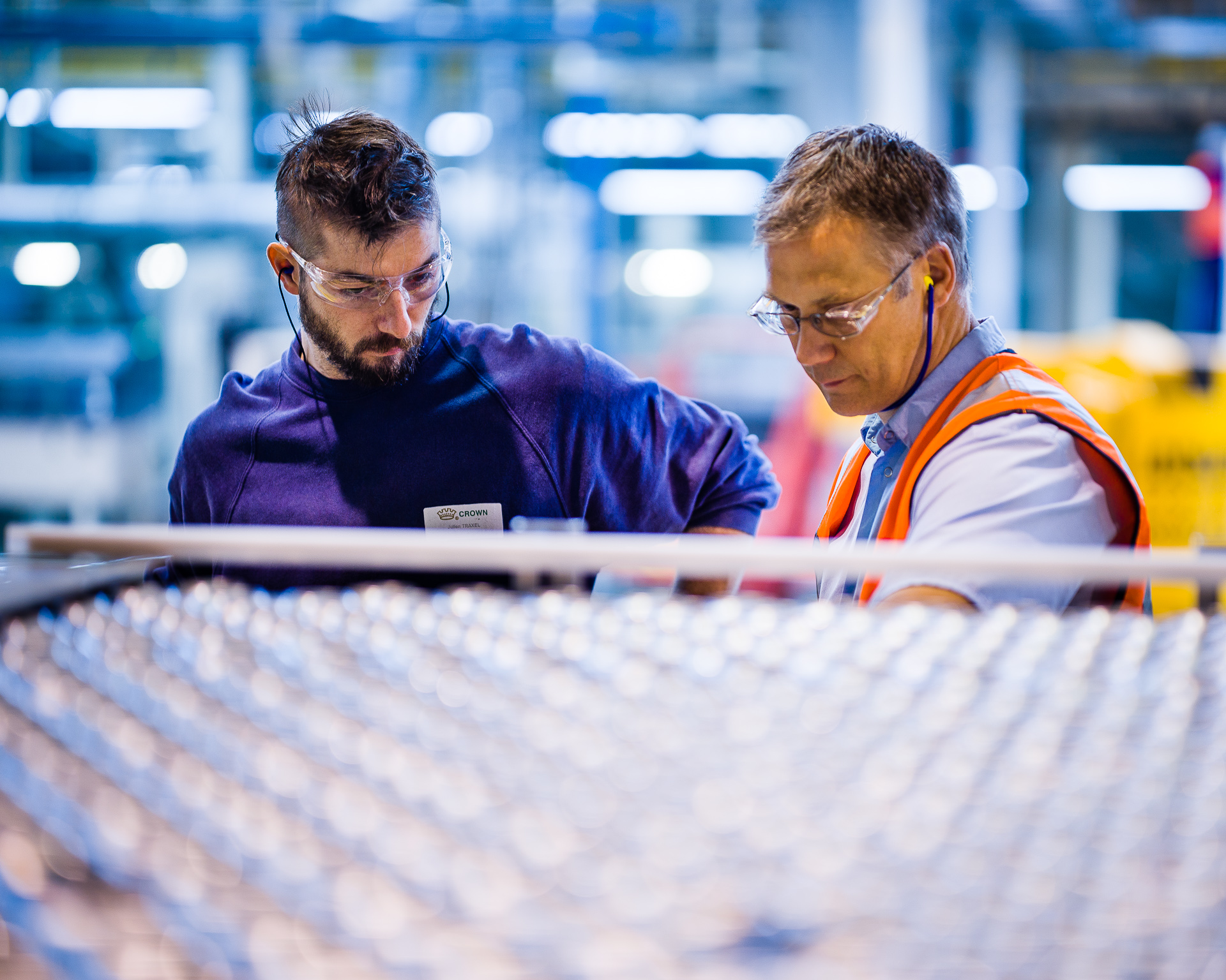 Two men in factory with safety glasses and ear protection