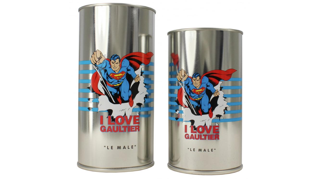 Two aluminum tin cans with image of superman flying through tin for Jean Paul Gaultier Le Male fragrance with text "I Love Gaultier"