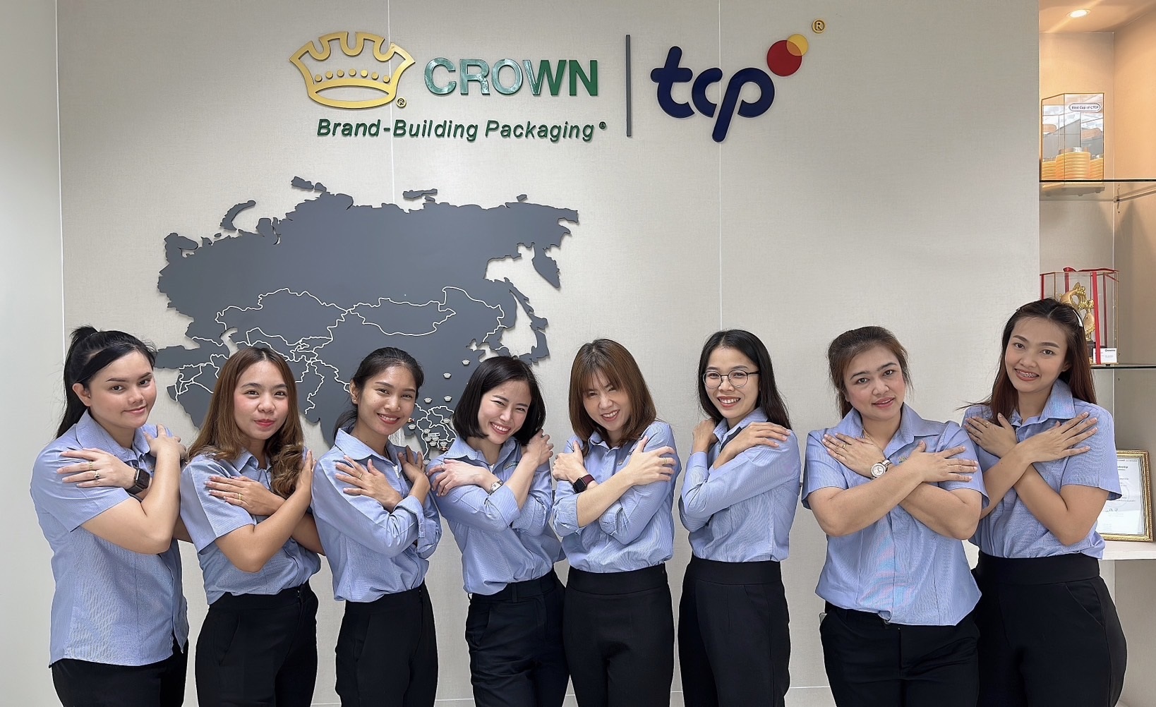 Eight women standing in front of Crown sign with arms crossed