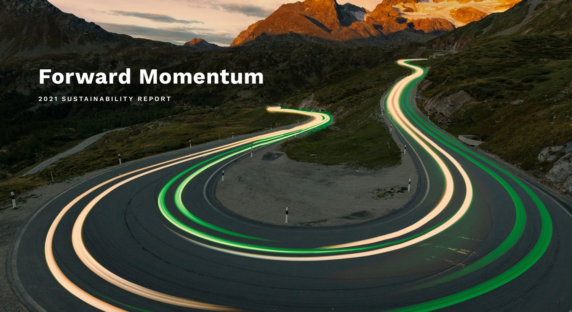 A winding road at sunset features green and yellowish streaks of light, implying cars driving quickly by. Overlaid is the text Forward Momentum: 2021 Sustainability Report