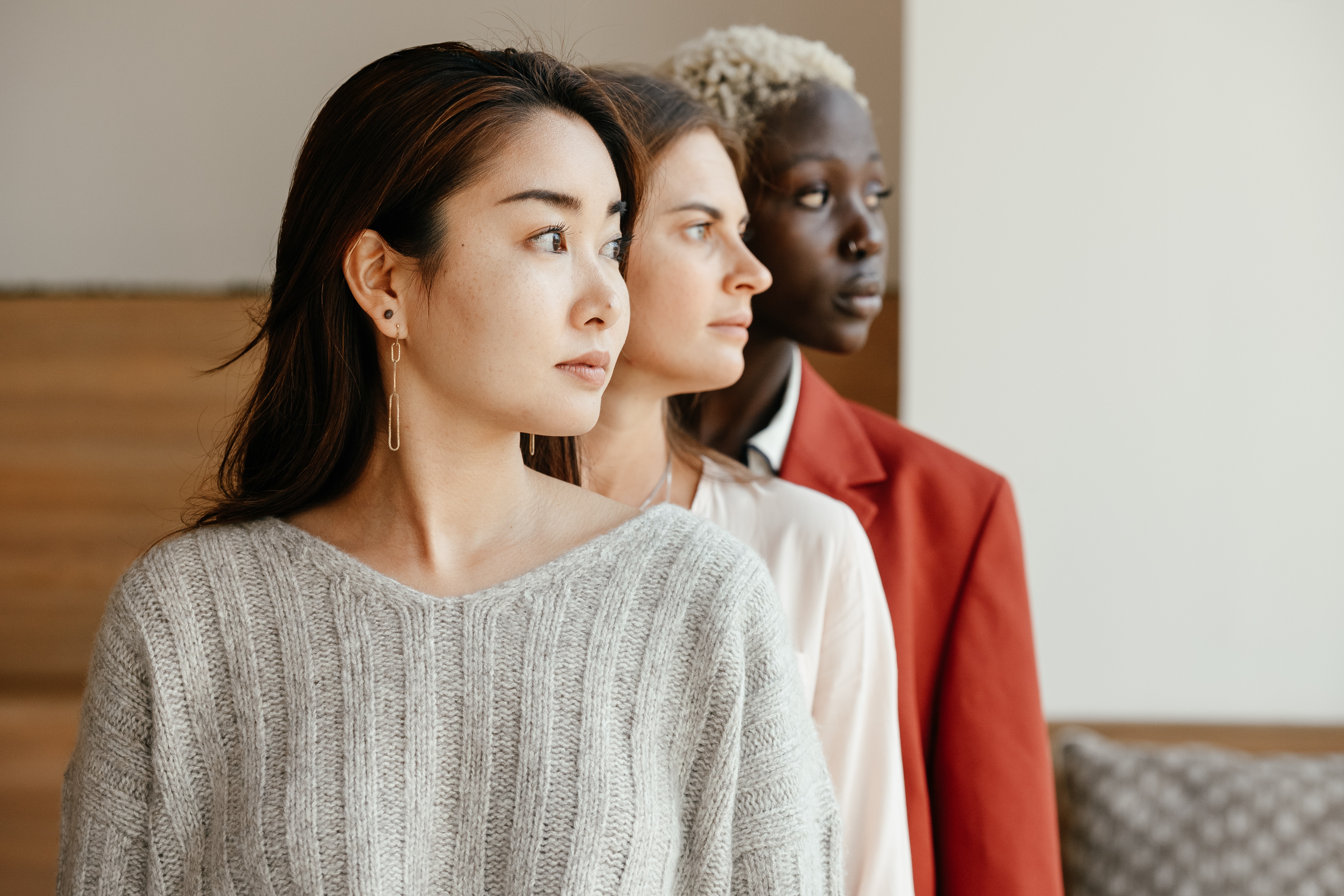 Three female-presenting individuals looking out into the distance